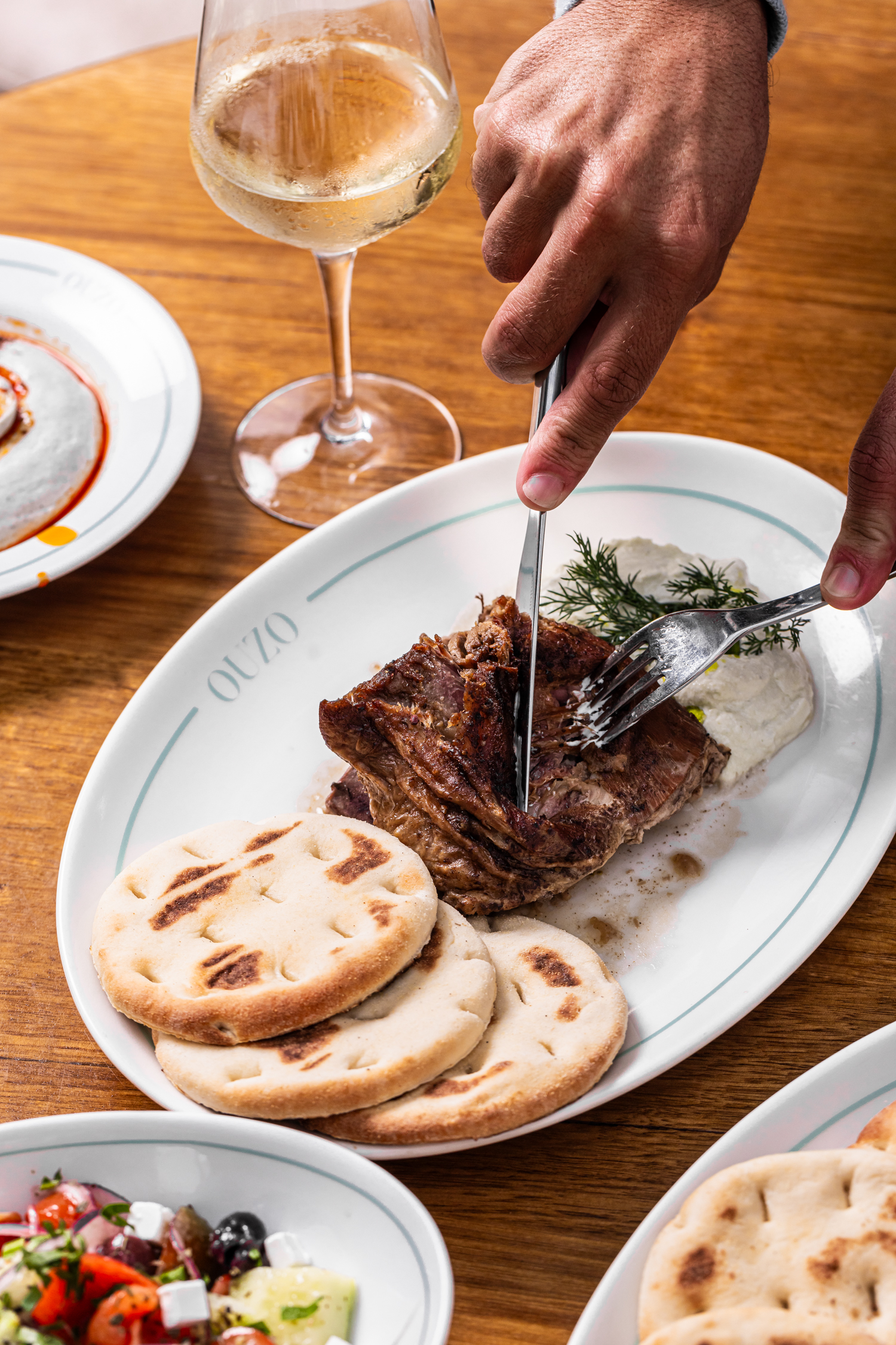 Slow-cooked lamb carved tableside with warm pita